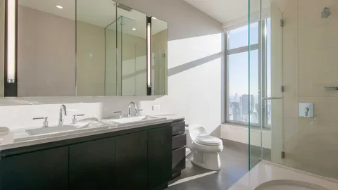a bathroom with a double vanity sink toilet and a mirror