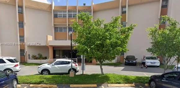 a front view of a house with garden and parking