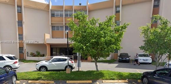 a front view of a house with garden and parking