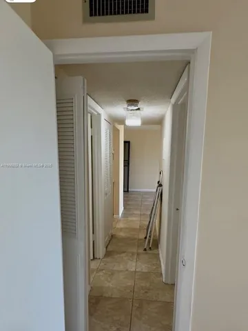 a view of an empty room with a chandelier fan