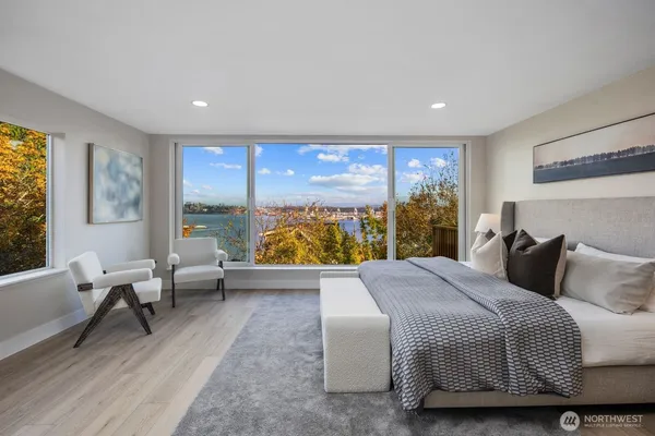 a bedroom with a bed and large windows