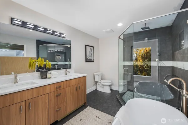a spacious bathroom with a double vanity sink a mirror and a toilet