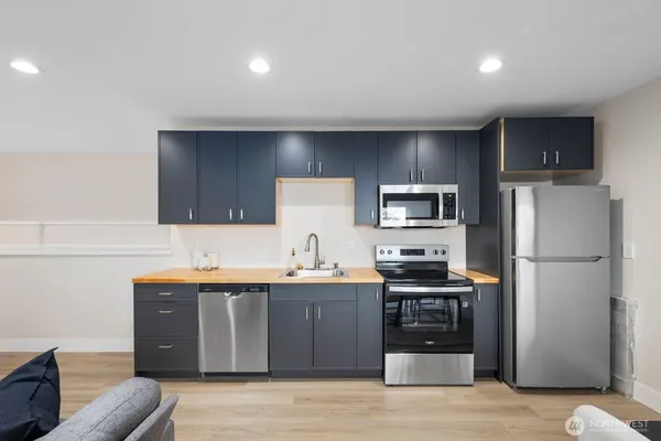 a kitchen with stainless steel appliances granite countertop a refrigerator a sink a stove a microwave and island