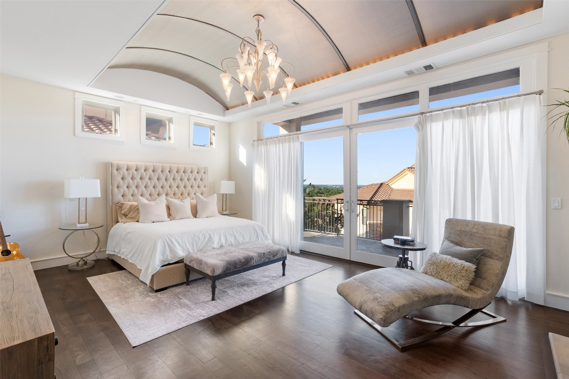 7025 Cielo Azul Pass Austin, TX 78732 - Photo 14 of 35 a spacious bedroom with a bed couch chandelier windows and a rug