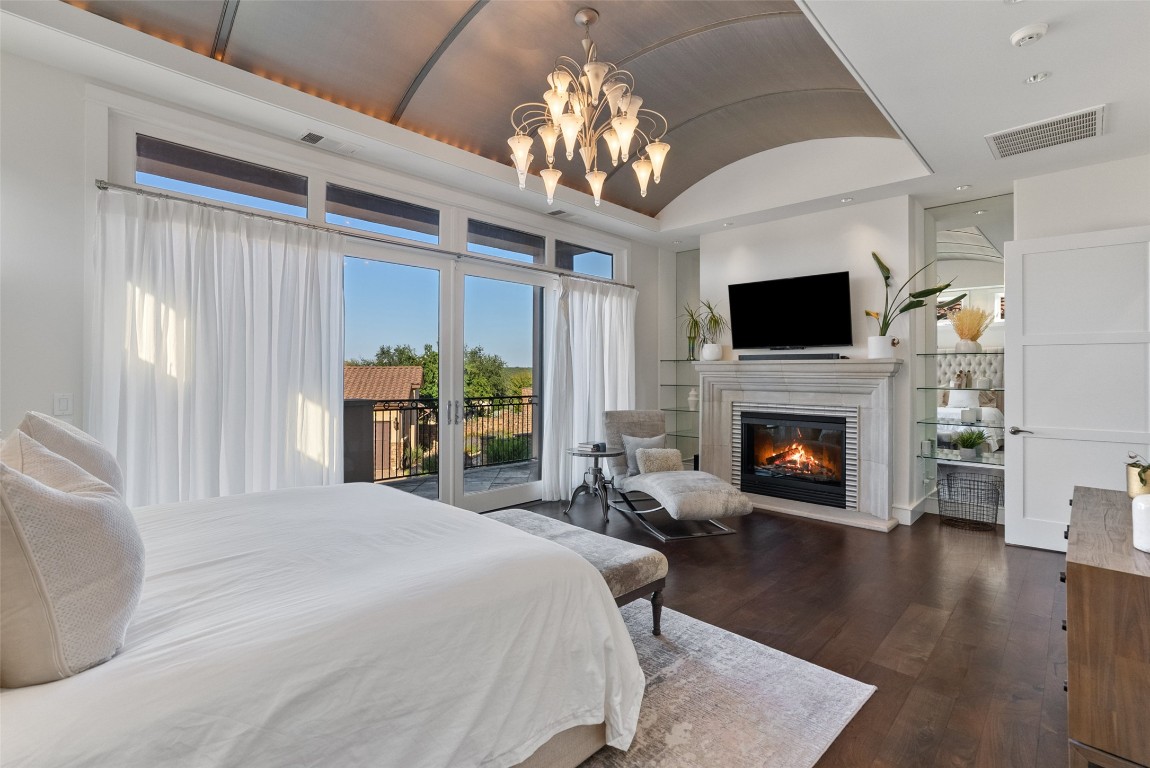 7025 Cielo Azul Pass Austin, TX 78732 - Photo 15 of 35 a spacious bedroom with a bed and a fireplace