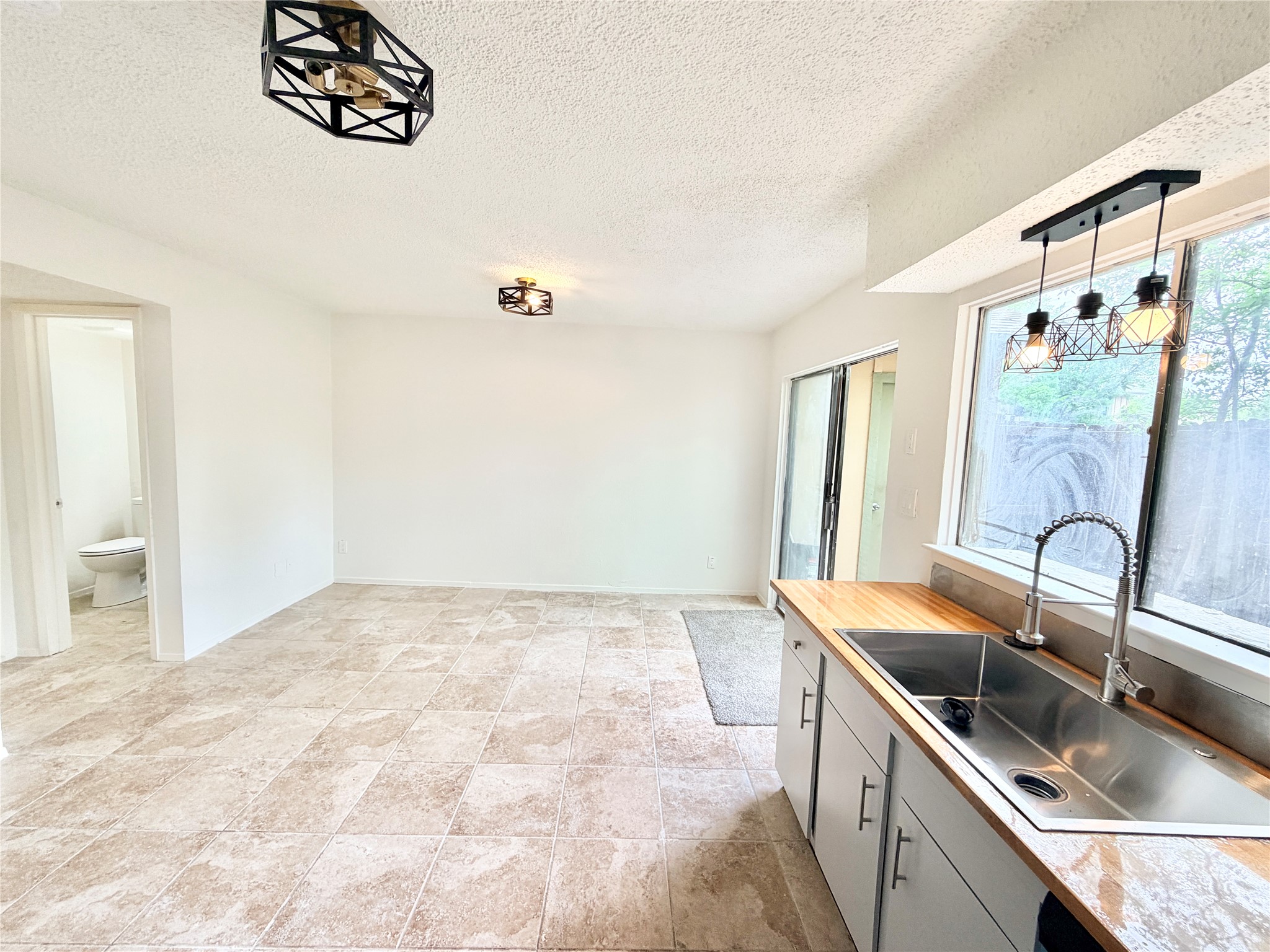 9623 Covey Ridge Lane Austin, TX 78758 - Photo 40 of 40 Kitchen with decorative light fixtures, a textured ceiling, and open floor plan
