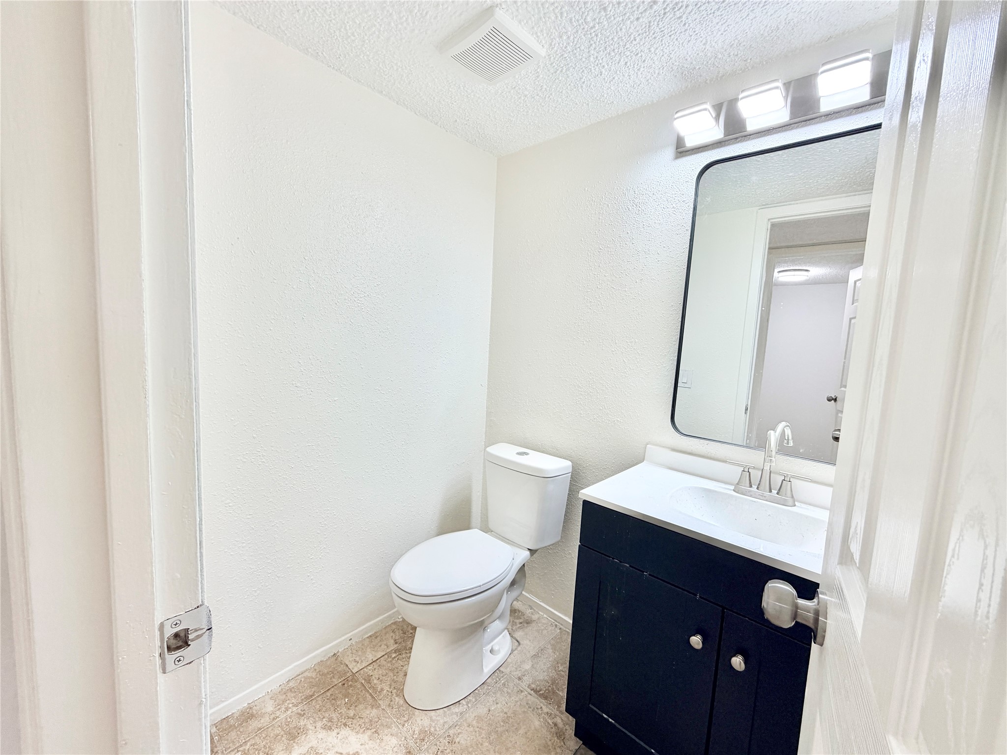 9623 Covey Ridge Lane Austin, TX 78758 - Photo 17 of 40 Bathroom with vanity, a textured ceiling, a textured wall, and light tile patterned floors