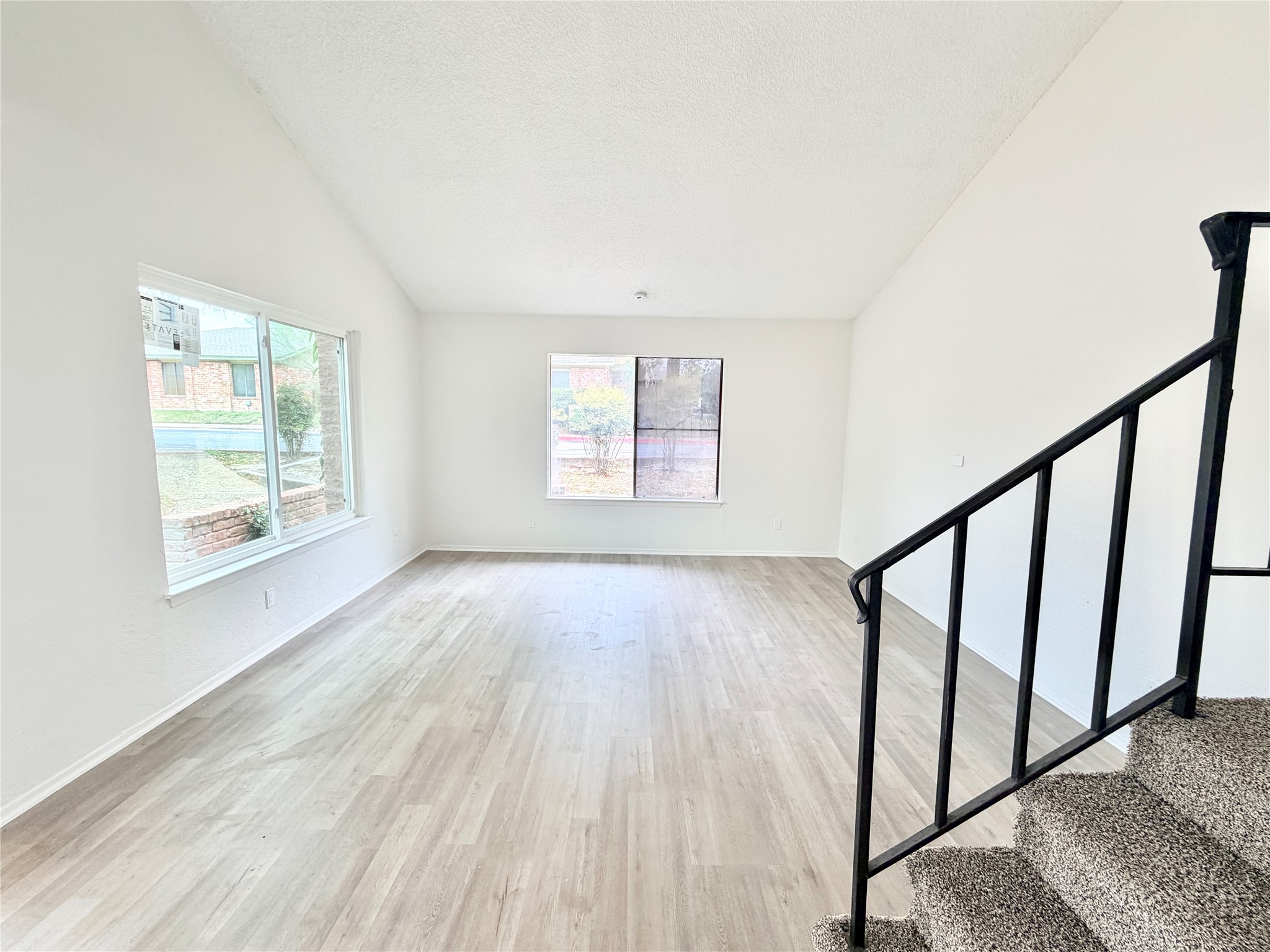 9623 Covey Ridge Lane Austin, TX 78758 - Photo 20 of 40 Unfurnished living room with stairs and light wood finished floors