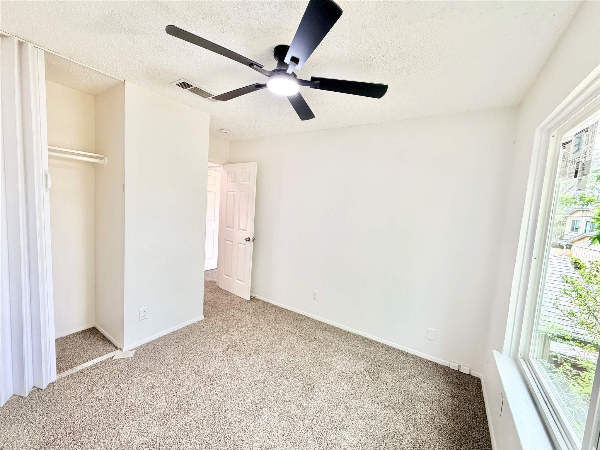 9623 Covey Ridge Lane Austin, TX 78758 - Photo 27 of 40 Unfurnished bedroom featuring carpet, a ceiling fan, a textured ceiling, and a closet