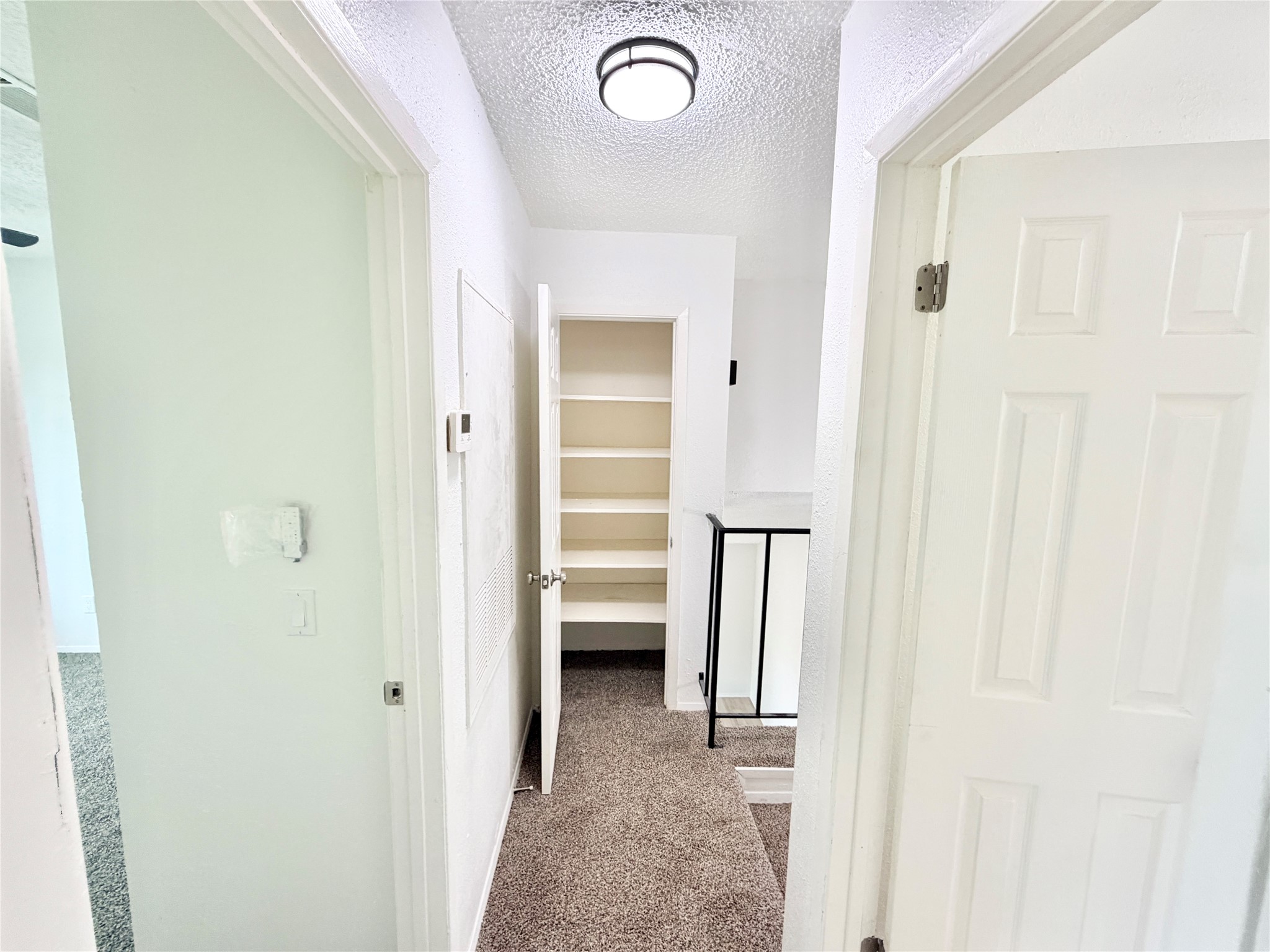 9623 Covey Ridge Lane Austin, TX 78758 - Photo 38 of 40 Corridor featuring light carpet and a textured ceiling
