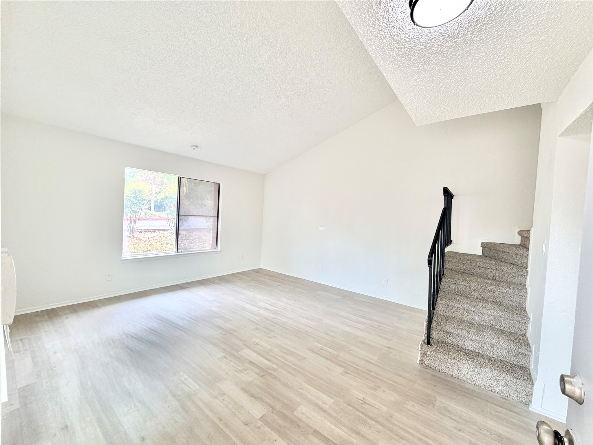 9623 Covey Ridge Lane Austin, TX 78758 - Photo 7 of 40 Unfurnished living room with stairway and light wood-style floors