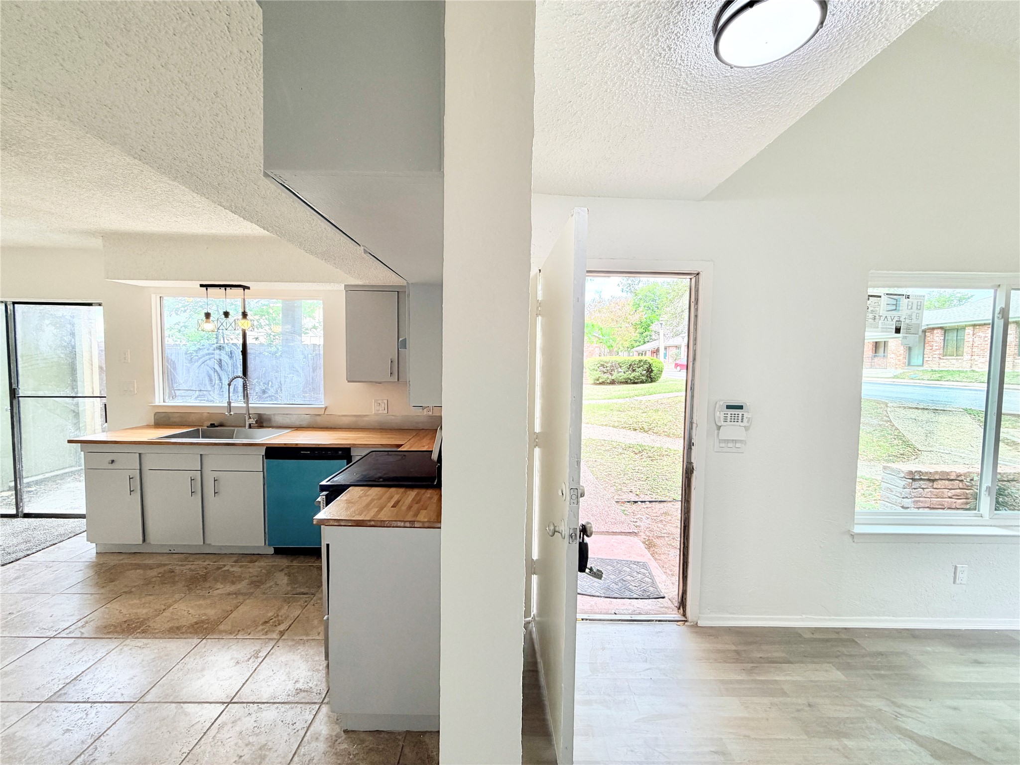 9623 Covey Ridge Lane Austin, TX 78758 - Photo 8 of 40 Kitchen with a textured ceiling, dishwasher, hanging light fixtures, and wooden counters