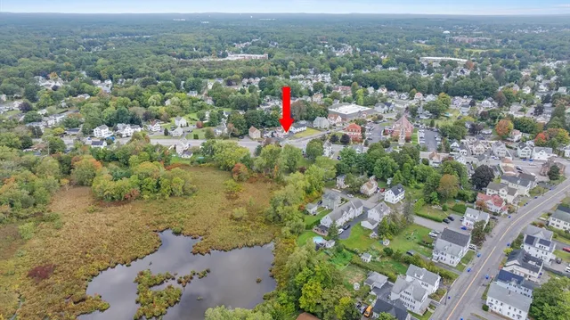 an aerial view of residential houses with outdoor space and trees