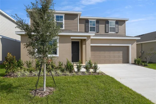 a front view of a house with a yard and garage