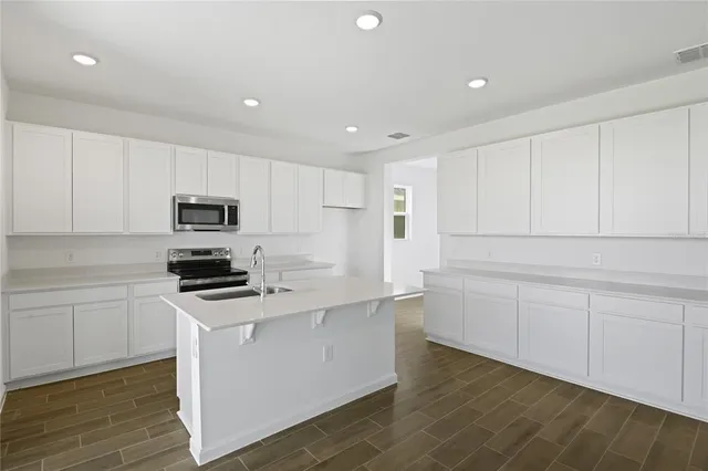 a kitchen with white cabinets sink and stainless steel appliances