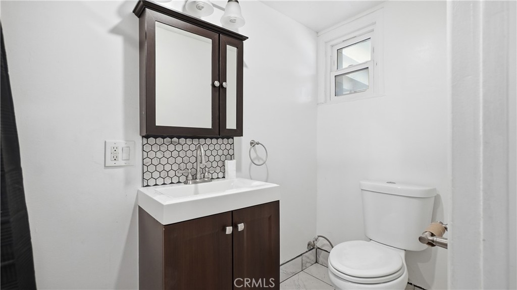 10568 Foothill Boulevard Sylmar, CA 91342 - Photo 20 of 34 a bathroom with a sink a toilet and mirror