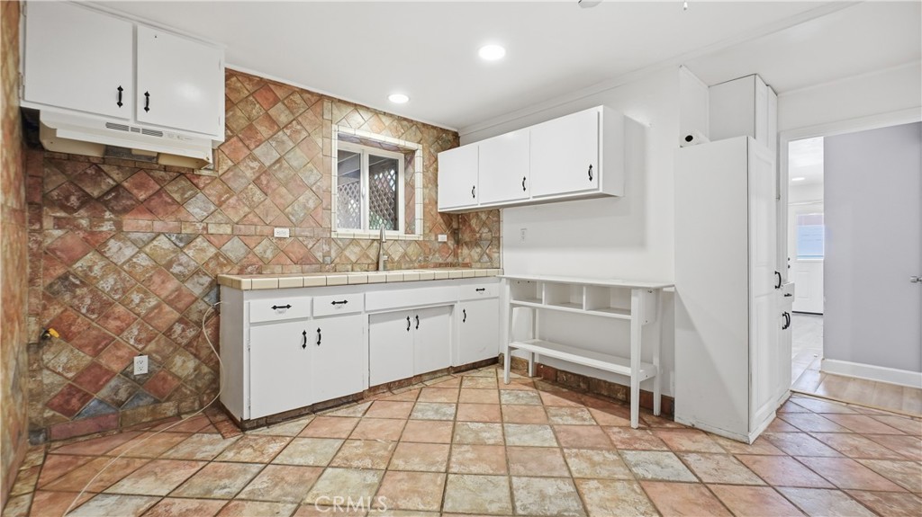 10568 Foothill Boulevard Sylmar, CA 91342 - Photo 23 of 34 a kitchen with white cabinets appliances and a sink