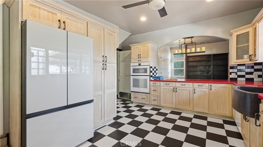 10568 Foothill Boulevard Sylmar, CA 91342 - Photo 8 of 34 a kitchen with a checkered floor and white cabinets