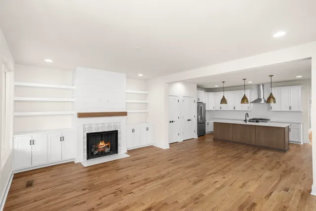 a large kitchen with a stove top oven and chandelier