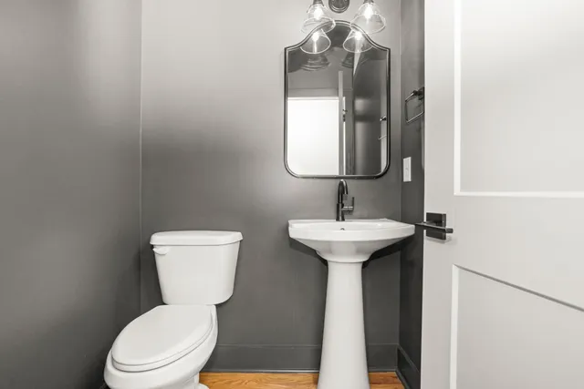 a bathroom with a toilet sink and mirror