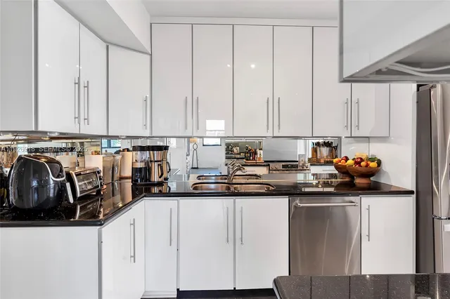 a kitchen with stainless steel appliances granite countertop a sink a stove and cabinets