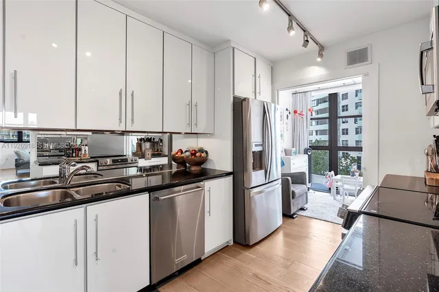 a kitchen with stainless steel appliances granite countertop a refrigerator and a sink