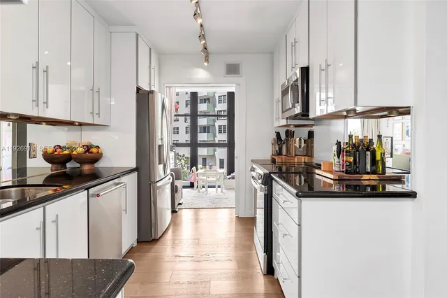 a kitchen with stainless steel appliances a sink a stove and cabinets