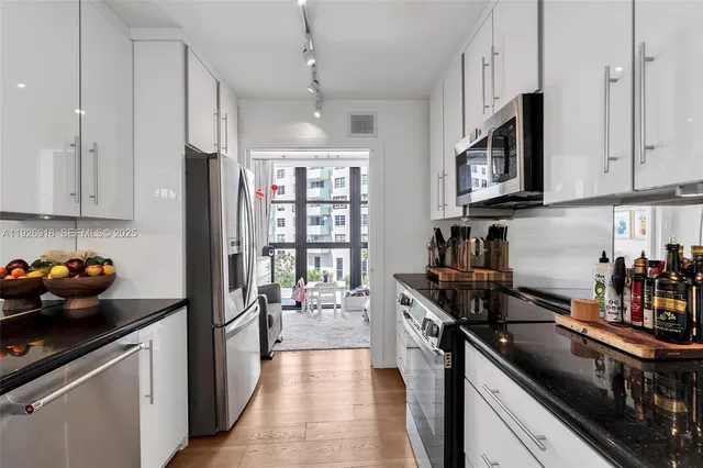 a kitchen with stainless steel appliances a stove a sink and a refrigerator