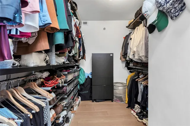 a view of walk in closet with clothes and shoes
