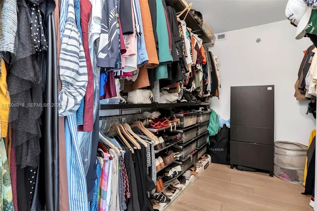 a view of walk in closet with clothes