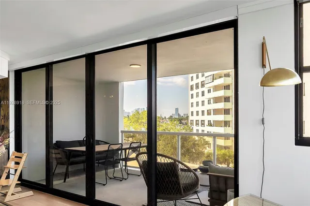 a view of a living room with furniture and floor to ceiling window