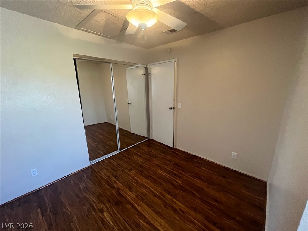 914 Scarlet Ridge Drive Las Vegas, NV 89128 - Photo 20 of 25 Rich wood flooring complements mirrored closet doors and a ceiling fan in this cozy bedroom.