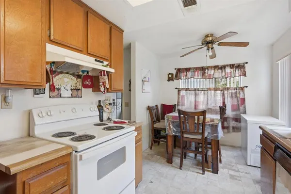a kitchen that has a stove a table and chairs in it