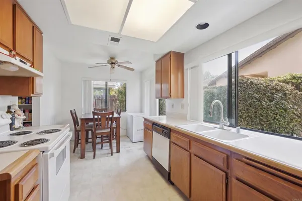 a large kitchen with kitchen island a large window in it