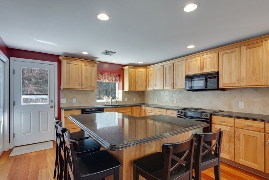 233 Ashburnham State Road Westminster, MA 01473 - Photo 16 of 42 a kitchen with a table chairs microwave and cabinets