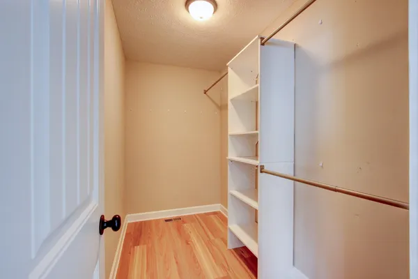 a view of walk in closet with empty racks