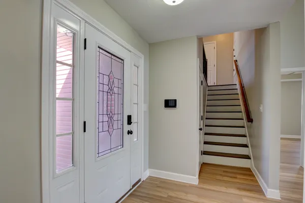 a view of a hallway with entryway wooden floor and front door