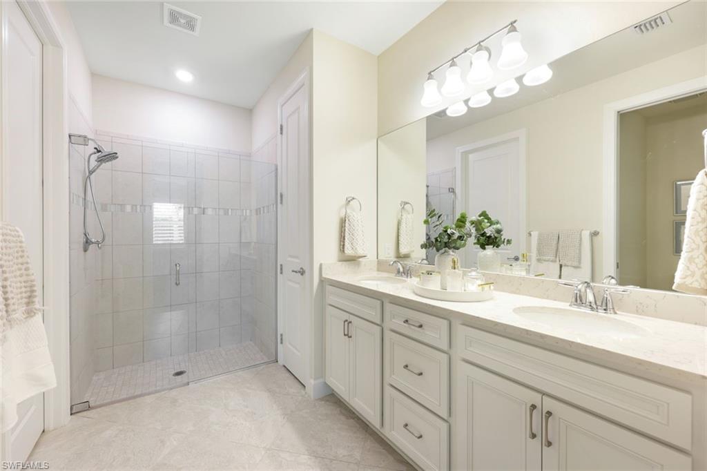 10763 Manatee Key Lane Estero, FL 33928 - Photo 11 of 33 a bathroom with a shower sink double and mirror