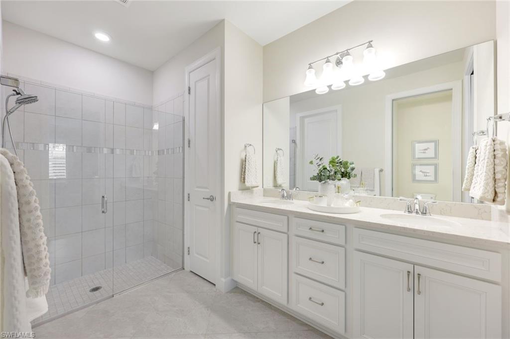 10763 Manatee Key Lane Estero, FL 33928 - Photo 12 of 33 a bathroom with a double vanity sink mirror and shower