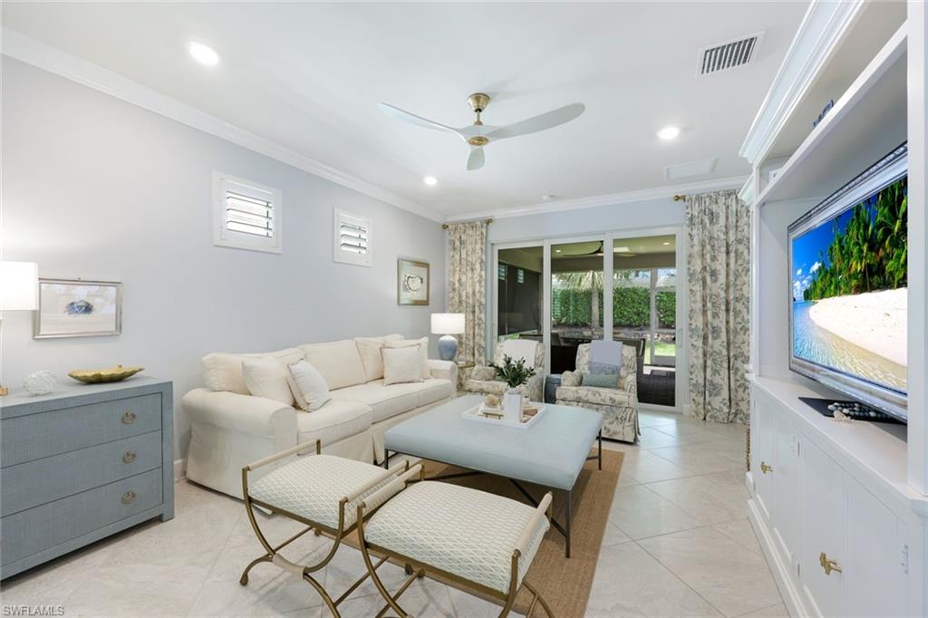 10763 Manatee Key Lane Estero, FL 33928 - Photo 2 of 33 a living room with furniture a flat screen tv and a large window