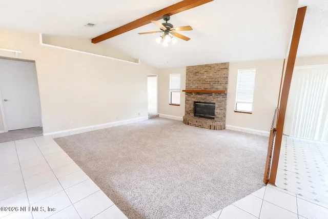 a view of a livingroom with an empty space and a fireplace