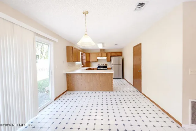 a kitchen view with granite countertop a sink and a refrigerator