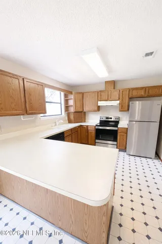 a kitchen with a sink a stove and a refrigerator