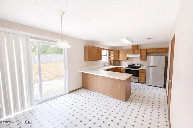 a kitchen with stainless steel appliances kitchen island granite countertop a refrigerator and a sink