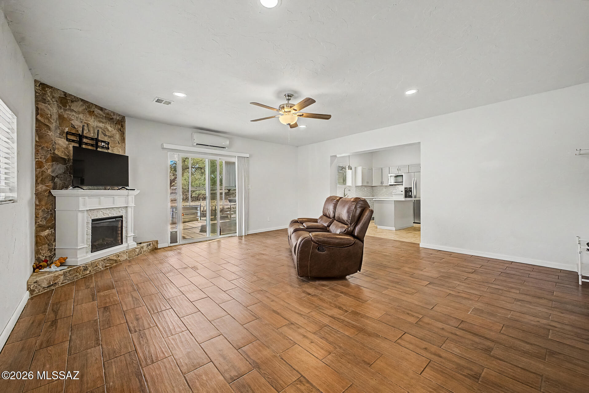 4231 East Pinal Street Tucson, AZ 85739 - Photo 28 of 36 a living room with furniture a fireplace and a flat screen tv