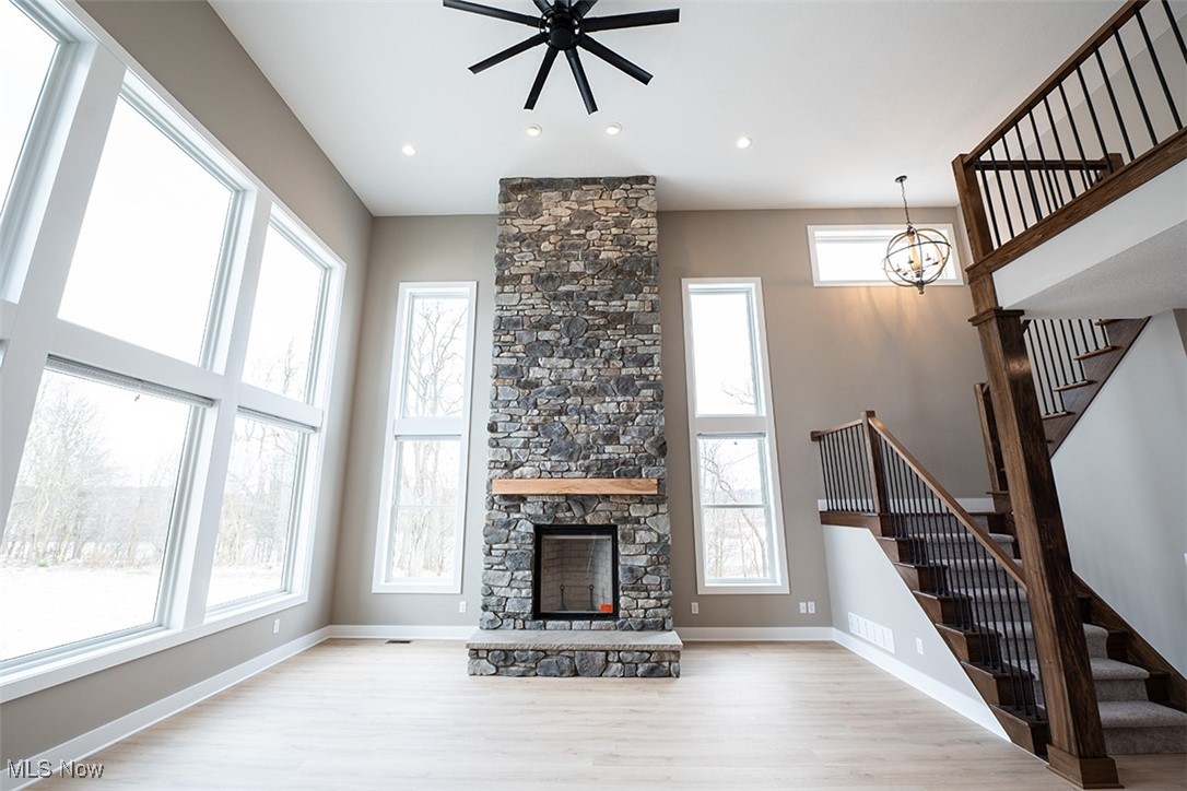 6960 State Road Wadsworth, OH 44281 - Photo 7 of 45 Unfurnished living room with a fireplace, light hardwood / wood-style flooring, and a healthy amount of sunlight