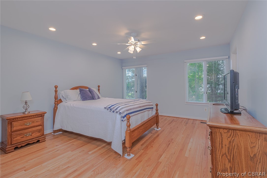 988 Queenstown Road Lancaster, VA 22503 - Photo 11 of 37 a bedroom with a bed and a flat tv screen on the dresser