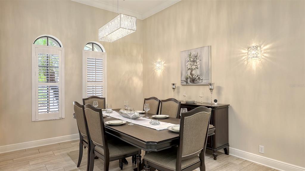 6919 Dominion Lane Lakewood Ranch, FL 34202 - Photo 14 of 99 a view of a dining room with furniture and chandelier