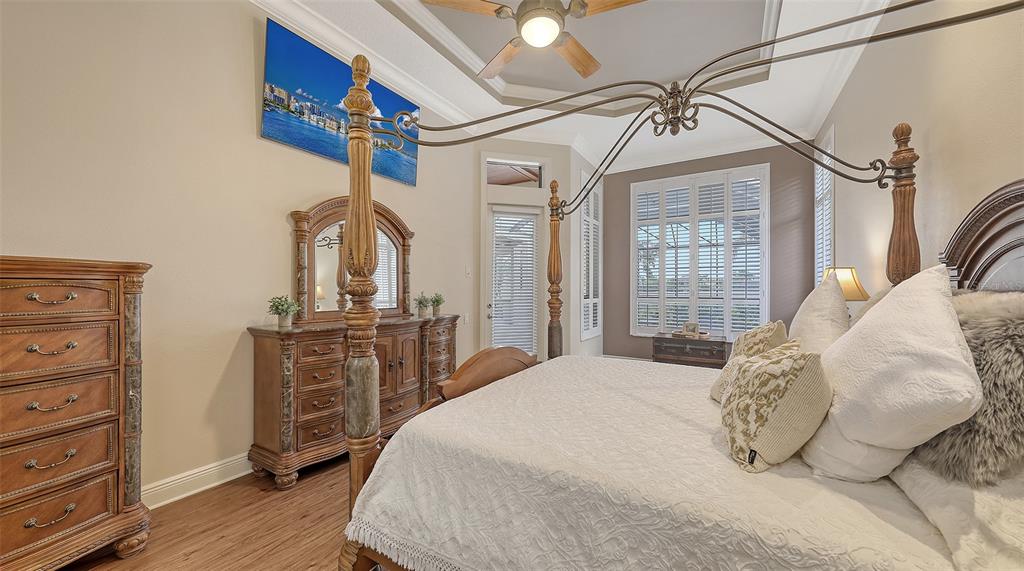 6919 Dominion Lane Lakewood Ranch, FL 34202 - Photo 32 of 99 a bedroom with a bed a dresser and potted plants