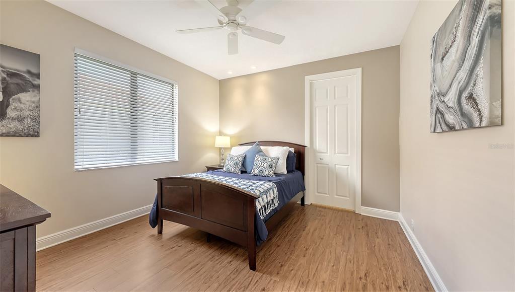 6919 Dominion Lane Lakewood Ranch, FL 34202 - Photo 47 of 99 a spacious bedroom with a bed and wooden floor